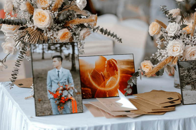 fake flowers centerpieces and photos on wedding reception table